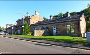 a large brick house on the side of a street at Paisley Central Apartment in Paisley