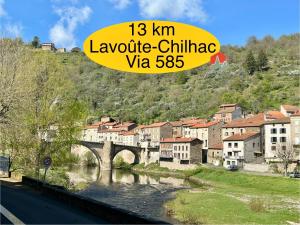 eine Stadt mit einer Brücke über einen Fluss und Gebäuden in der Unterkunft Abel Hôtel in Langeac