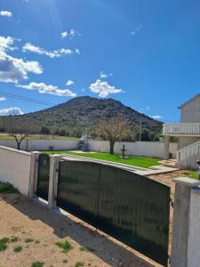 een zwarte poort met een berg op de achtergrond bij House Matan in Tisno