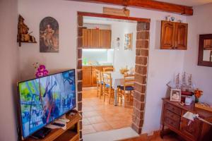 een woonkamer met een televisie en een eetkamer bij House Matan in Tisno