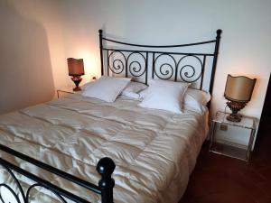 sypialnia z dużym łóżkiem z białymi poduszkami w obiekcie Casa Birtukan w mieście Massino Visconti