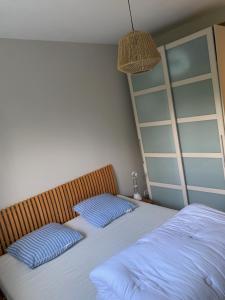 a bedroom with two beds with blue pillows at Maison 400m de la plage in Crozon