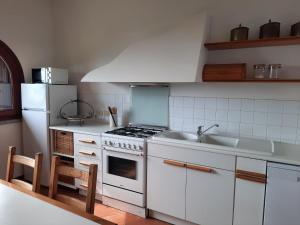 eine Küche mit einem Herd, einer Spüle und einem Kühlschrank in der Unterkunft Casa Birtukan in Massino Visconti