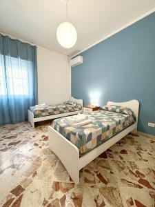 twee bedden in een kamer met blauwe muren bij Casa Indipendenza - Cattedrale in Palermo