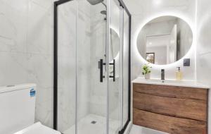 a bathroom with a shower and a toilet and a sink at Holiday Home at Huia Road in Auckland +5 photos
