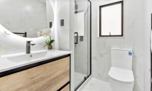 a bathroom with a toilet and a sink and a shower at Holiday Home at Huia Road in Auckland