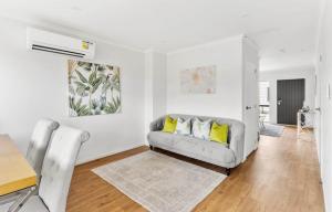 a living room with a couch and a table at Holiday Home at Huia Road in Auckland