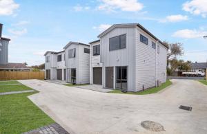 a row of modular homes with a driveway at Holiday Home at Huia Road in Auckland