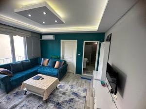 un soggiorno con divano blu e tavolo di Çam Suit 