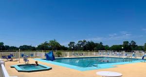 a swimming pool with chairs and people in it at Pet friendly tiny home, No extra fees! The Jitney in Clermont
