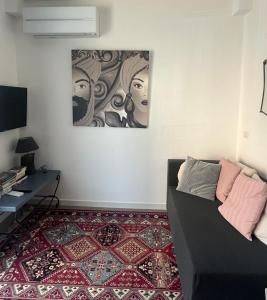 a living room with a couch and a painting on the wall at EcoCasa Neapolis in Siracusa