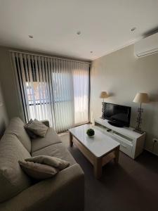 a living room with a couch and a coffee table at MET Apto en Las Dunas, Oliva Nova in Oliva