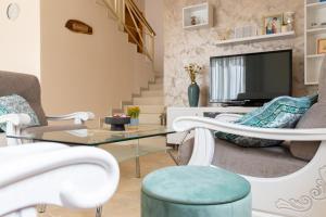 a living room with chairs and a table and a tv at Villa Pontem in Komarna