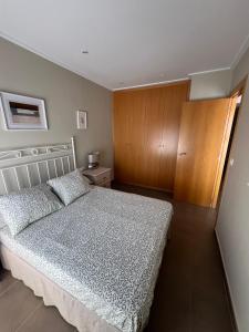 a bedroom with a bed and a wooden cabinet at MET Apto en Las Dunas, Oliva Nova in Oliva +19 photos