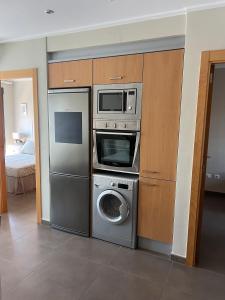 a kitchen with a washing machine and a microwave at MET Apto en Las Dunas, Oliva Nova in Oliva