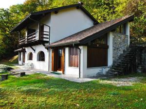 uma pequena casa branca com um alpendre e uma varanda em Casa Birtukan em Massino Visconti