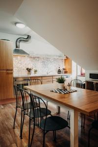 uma cozinha e sala de jantar com uma mesa de madeira e cadeiras em Chata u Cecila em Loučná nad Desnou