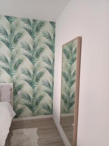 a mirror next to a wall with a mural of palm trees at Orotava Bliss Z in La Orotava