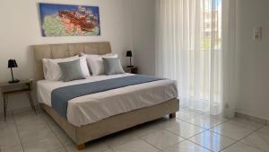 a bedroom with a large bed with white sheets and pillows at Golden Flower Luxury Apartment in Sitia