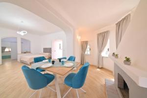 a dining room with a table and blue chairs at Villa Aida Luxury Apartments & Spa in Forio d'Ischia