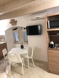 ein weißes Esszimmer mit einem weißen Tisch und Stühlen in der Unterkunft More Apartments il Ferrarese2 in Bari