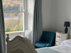 1 dormitorio con 1 cama, 1 silla y 1 ventana en Dale Head Hall Lakeside Hotel en Keswick
