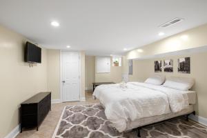 ein Schlafzimmer mit einem großen Bett und einem Flachbild-TV in der Unterkunft Lovely Vacation Home In The Grays Ferry Area in Philadelphia