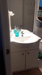 y baño con lavabo blanco y espejo. en 1 habitación comoda, en Santiago