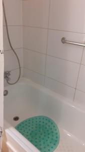 y baño con bañera blanca y aseo verde. en 1 habitación comoda, en Santiago