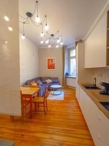 a kitchen and living room with a couch and a table at Mazurska Apartments na parterze z wejsciem na kod o dowolnej porze in Szczecin