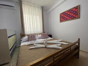 a bedroom with a bed with towels on it at Olive Tree Apartment in Sarandë