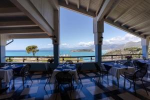 ein Restaurant mit Tischen und Stühlen und Meerblick in der Unterkunft Hotel Villa Principe in San Nicola Arcella