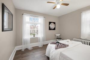 a white bedroom with a bed and a ceiling fan at Univ City Upenndrexel 2 Bdrm Amazing Unit in Philadelphia