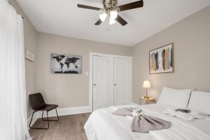 a white bedroom with a ceiling fan and a bed at Univ City Upenndrexel 2 Bdrm Amazing Unit in Philadelphia