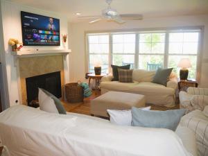 a living room with couches and a fireplace with a tv at Sandhill House - Spectacular Lake Home With Toys! in Beulah