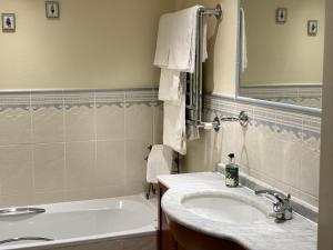 uma casa de banho com um lavatório e uma banheira em Dale Head Hall Lakeside Hotel em Keswick