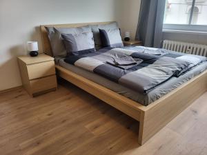 a large bed in a bedroom with a wooden floor at Apartmán Susan in Brno