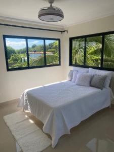 a bedroom with a large bed with two large windows at Apartamento con agua caliente para 9 personas in La Ureña