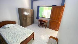 a bedroom with a bed and a cabinet and a table at Casa Reátegui in Iquitos