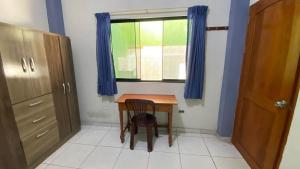 a small table and chair in a room with a window at Casa Reátegui in Iquitos