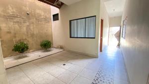 a hallway with a tile floor and a wall with two plants at Casa Reátegui in Iquitos