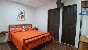 a bedroom with a bed with an orange bedspread at Casa Blanca in San Carlos