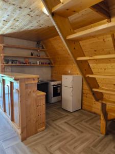 a kitchen in a log cabin with a refrigerator at Bosaca in Žabljak