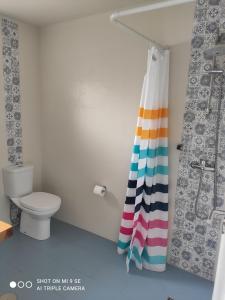a bathroom with a shower curtain and a toilet at Yellow Door in Gafanha da Encarnação +29 photos