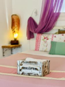 uma caixa de madeira em cima de uma cama em Errika's Sweet Home em Provatas