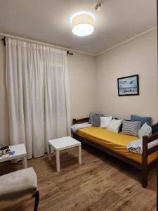 sypialnia z łóżkiem z żółtym kocem w obiekcie RoomsApartments PopCOURT w mieście Pančevo