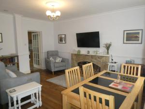ein Wohnzimmer mit Tisch und Kamin in der Unterkunft Aln Cottage Alnwick in Alnwick