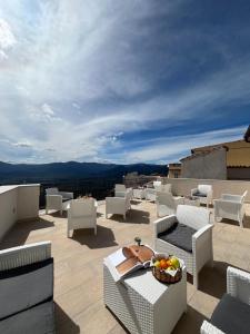 a patio with chairs and a bowl of fruit on a roof at Su Murcone Appartamento Baunei in Baunei