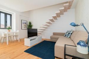 uma sala de estar com um sofá e uma escada em Belém Design Apartments by Homing em Lisboa