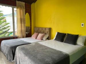 two beds in a room with a yellow wall at Holiday House - 3 Bedroom 3 Bathroom in Baños